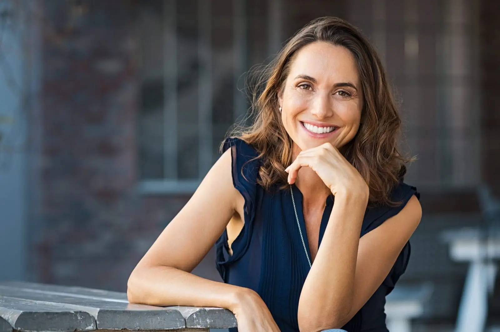 Mature woman smiling confidently with natural-looking dentures